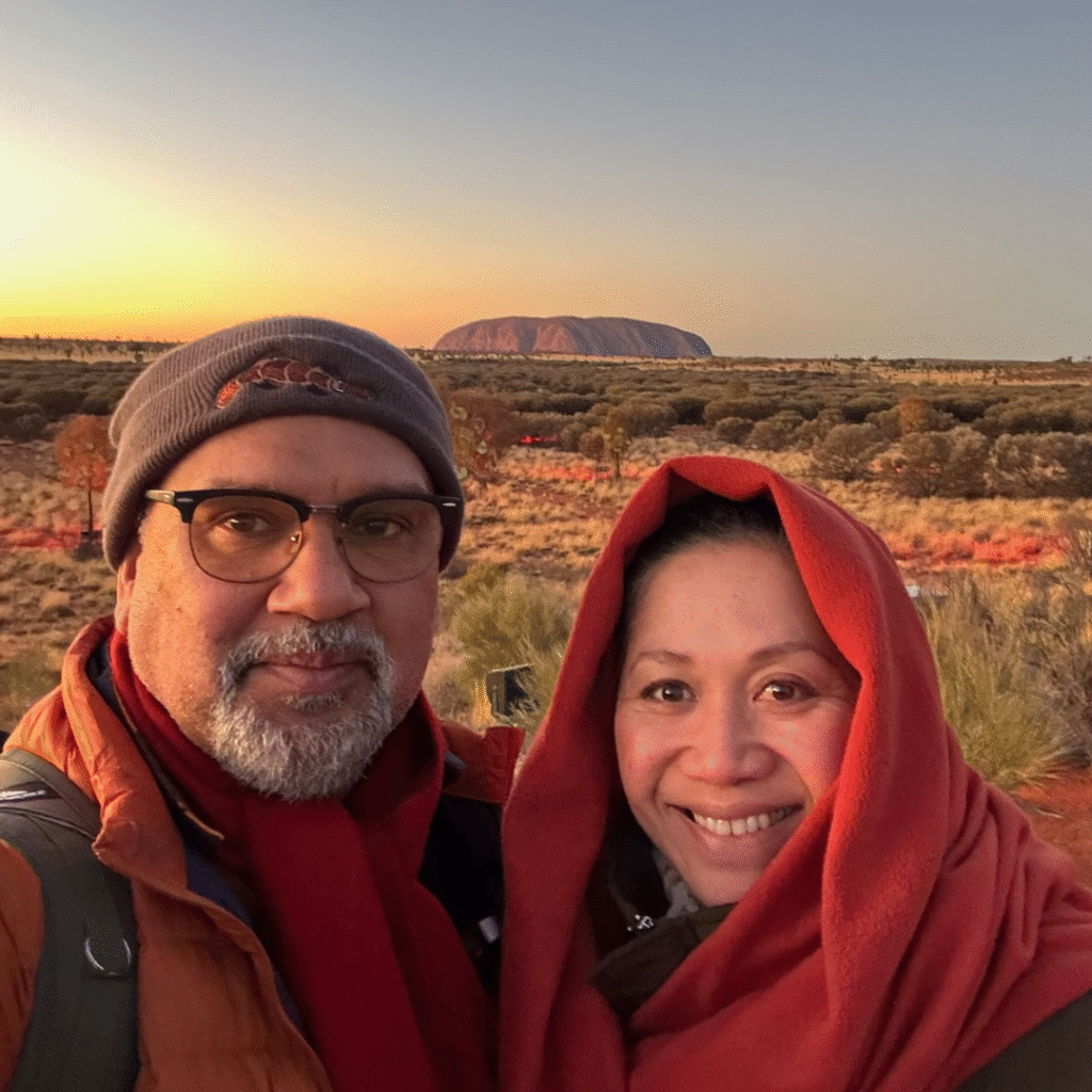 Mark Yettica-Paulson and Maryann Talia Pau at Uluru at sunrise, inviting readers to explore cultural stories and reflections on the Damper & Fetū blog.